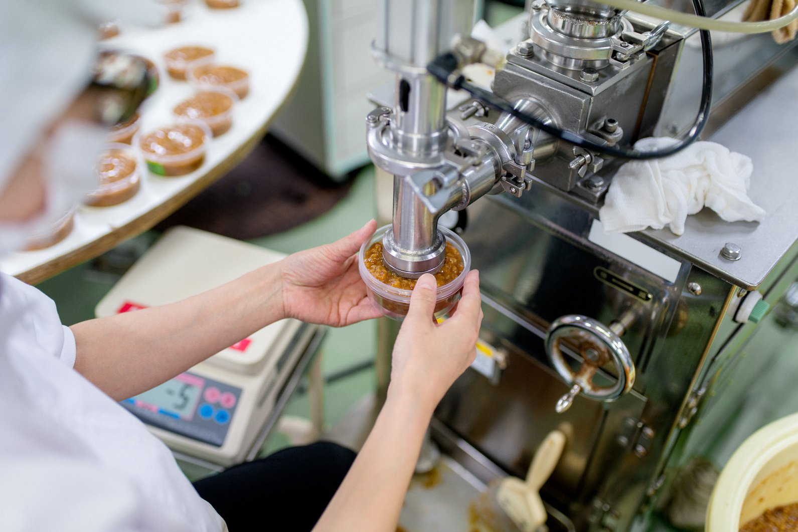 Worker in a food processing factory packaging food